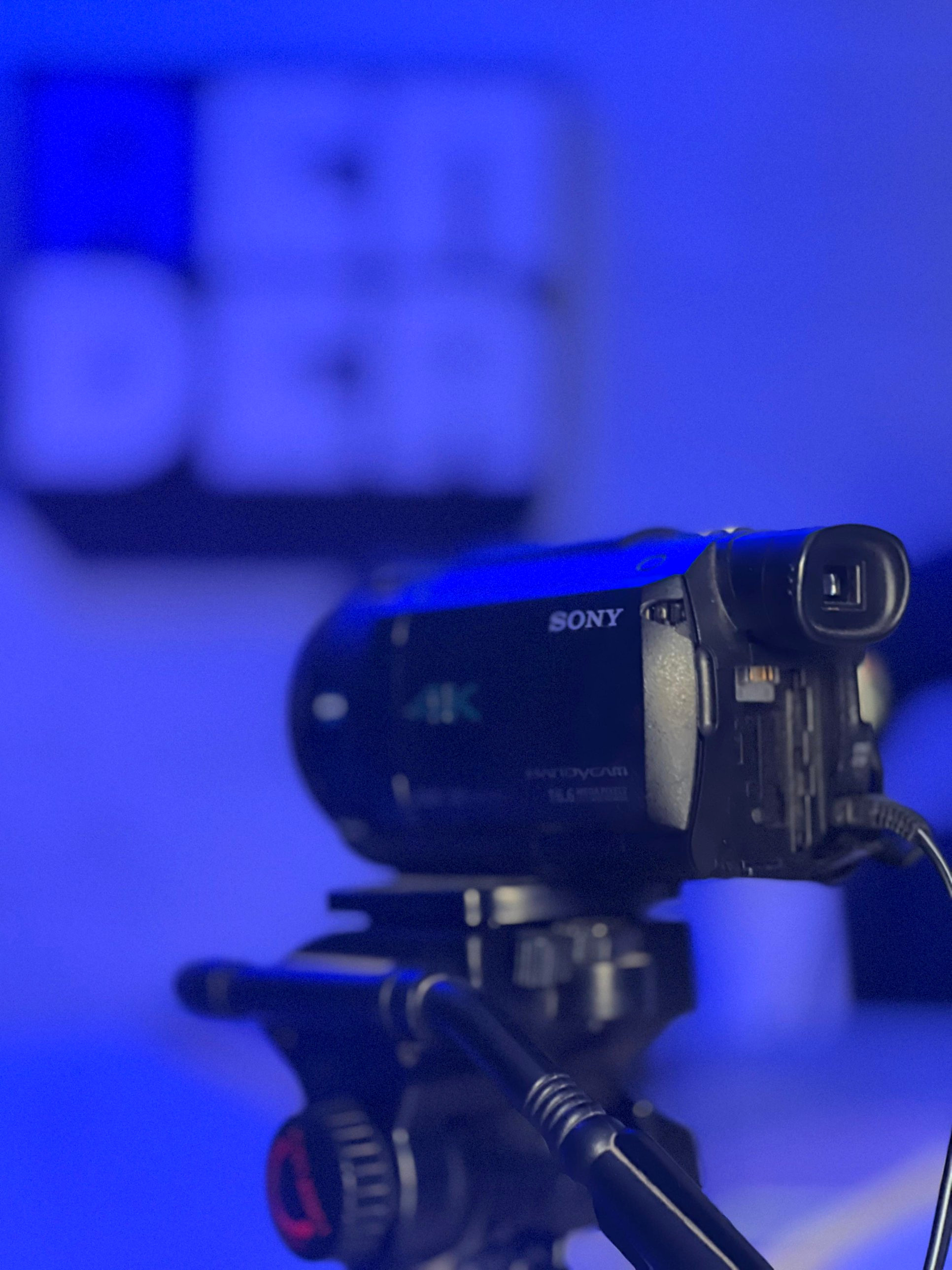 Cámara Sony 4K en trípode, con el logo de Render desenfocado de fondo