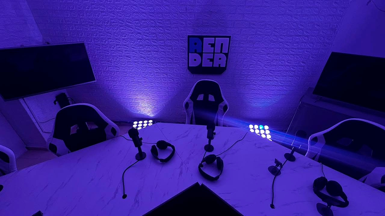 El set con las luces encendidas, la mesa con micrófonos y el logo de Render