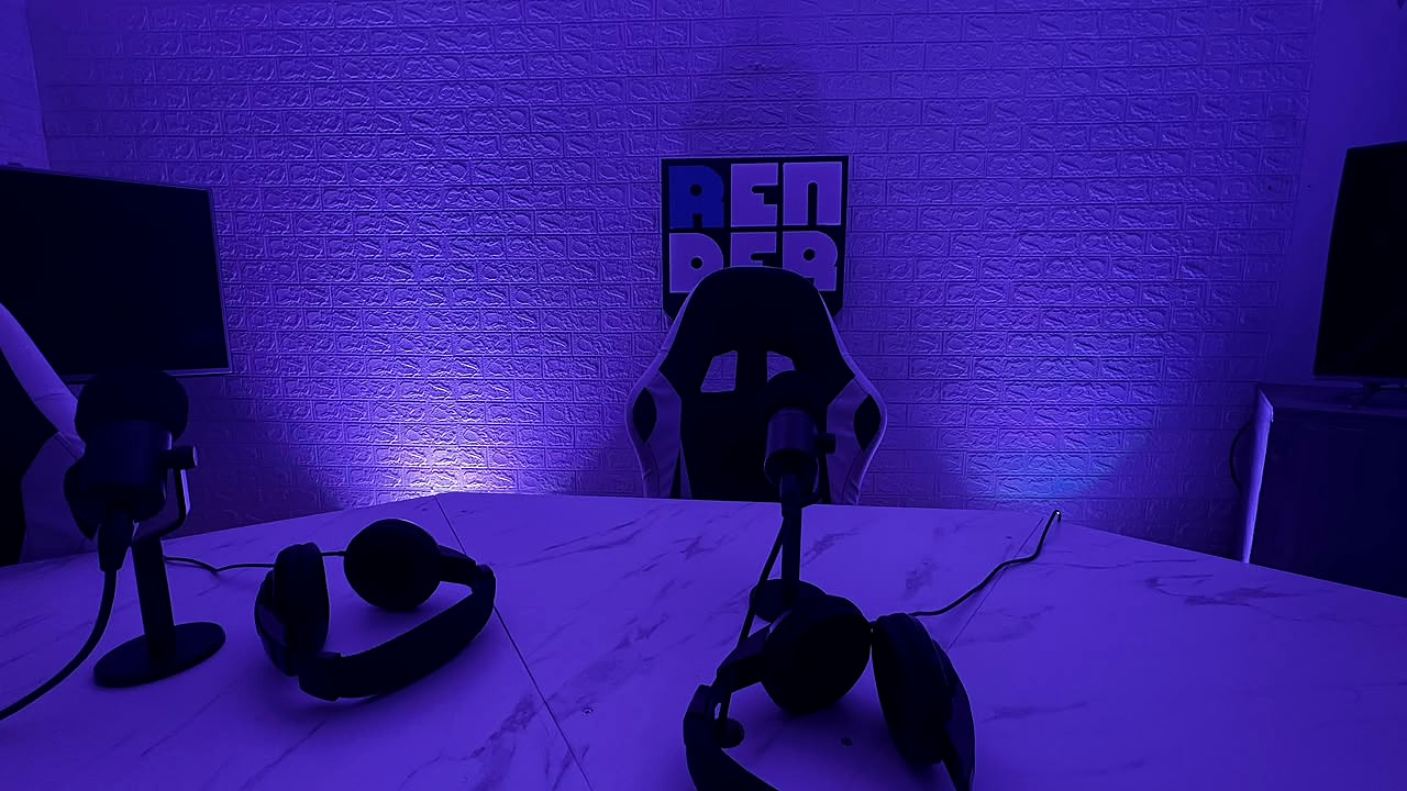 El estudio de Render: mesa con micrófonos y auriculares frente al logo en la pared